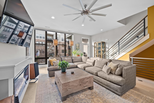 living room featuring light wood-type flooring, floor to ceiling windows, and ceiling fan