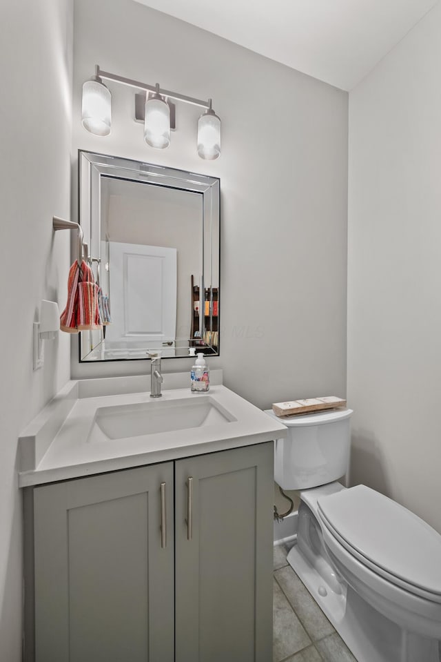 bathroom with tile patterned flooring, vanity, and toilet