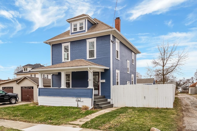 view of front of house with a porch, an outbuilding, a garage, and a front yard