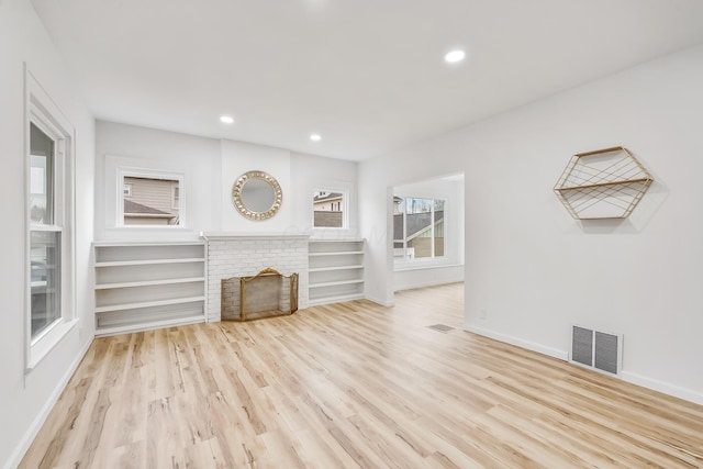 unfurnished living room featuring a fireplace and light hardwood / wood-style flooring