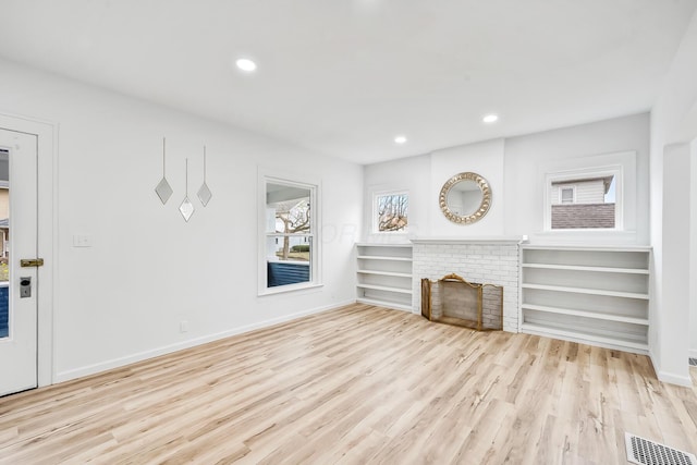 unfurnished living room featuring a fireplace and light hardwood / wood-style floors