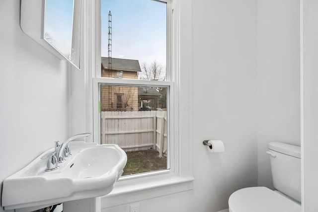 bathroom featuring sink, plenty of natural light, and toilet