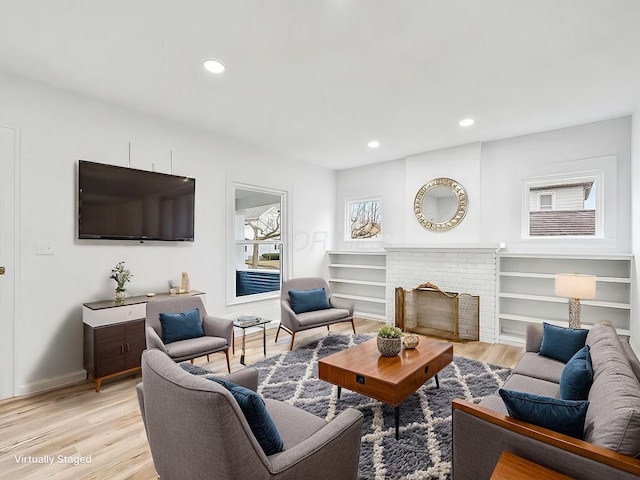 living room with a fireplace and light hardwood / wood-style flooring