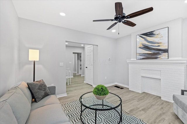 living room featuring ceiling fan and light hardwood / wood-style flooring