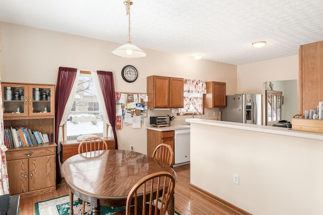 dining area with sink, light hardwood / wood-style floors, and a textured ceiling