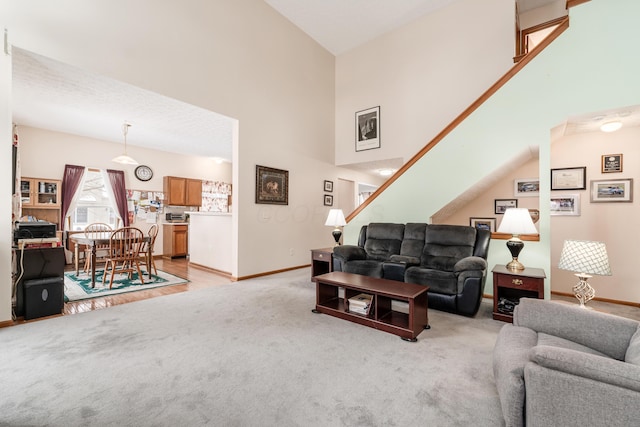 carpeted living room with high vaulted ceiling