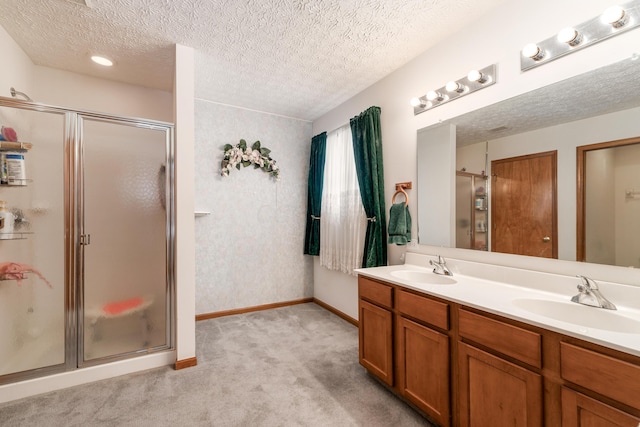 bathroom with vanity, a textured ceiling, and walk in shower