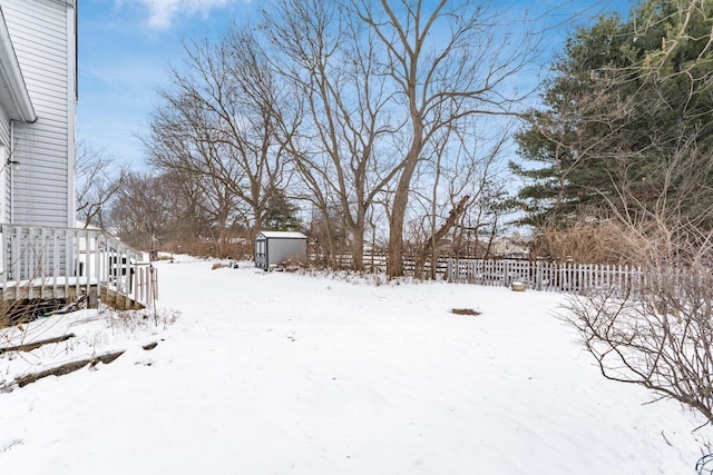 yard layered in snow featuring a shed