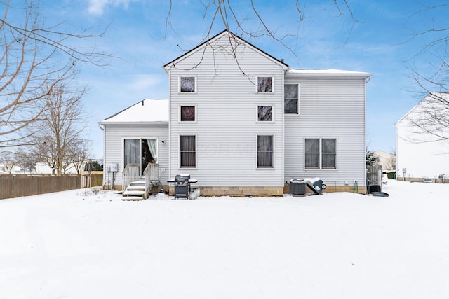 snow covered back of property with cooling unit