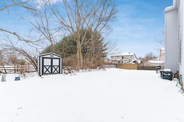 yard covered in snow with a shed