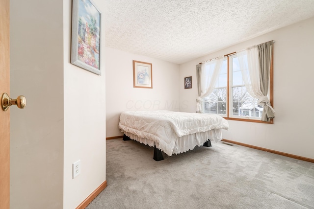 carpeted bedroom featuring a textured ceiling