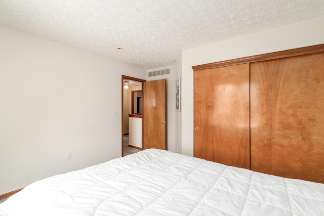 unfurnished bedroom with a textured ceiling and a closet