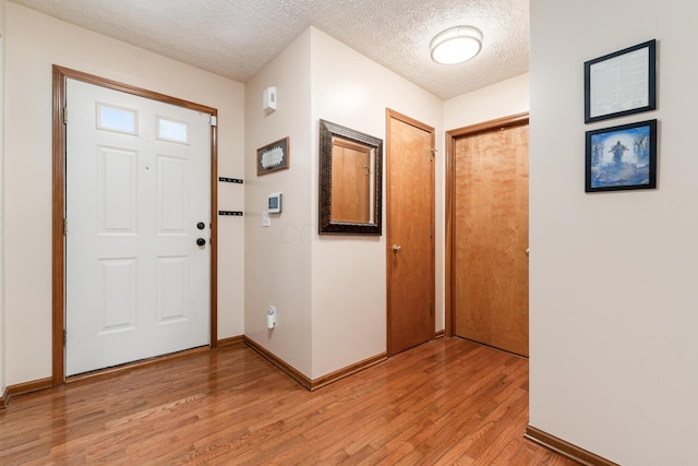 entrance foyer with light hardwood / wood-style flooring and a textured ceiling