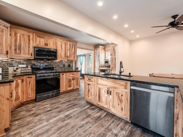 kitchen featuring sink, dark hardwood / wood-style flooring, tasteful backsplash, and appliances with stainless steel finishes