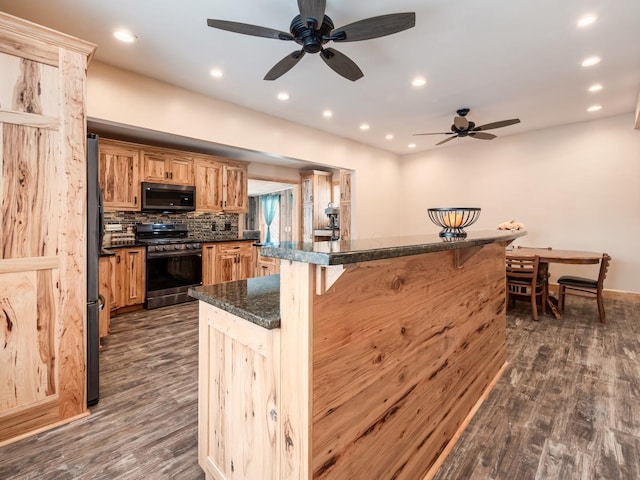 kitchen with stainless steel appliances, a kitchen bar, dark hardwood / wood-style floors, and backsplash