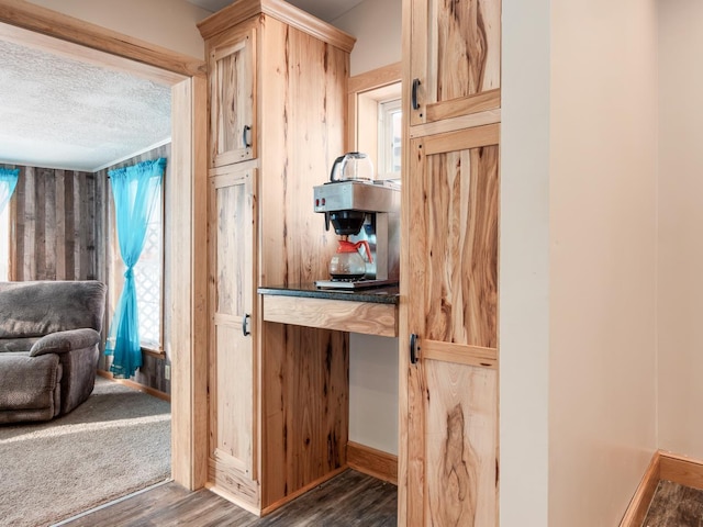 kitchen featuring dark wood-type flooring, light brown cabinets, and a textured ceiling