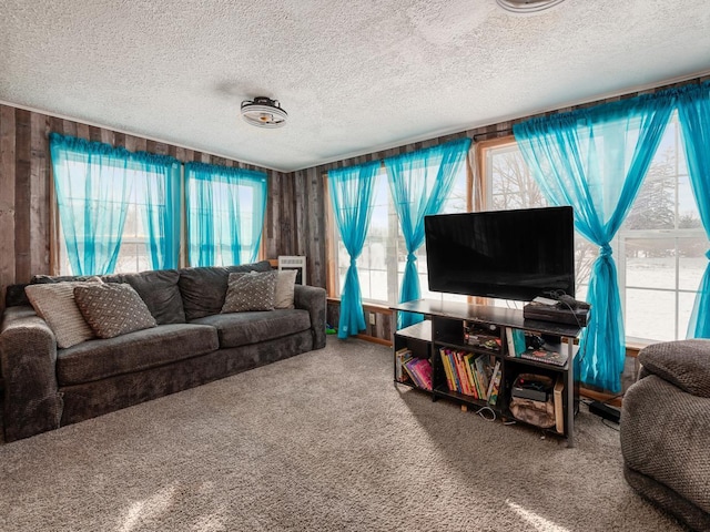 living room featuring carpet floors, a textured ceiling, and wooden walls