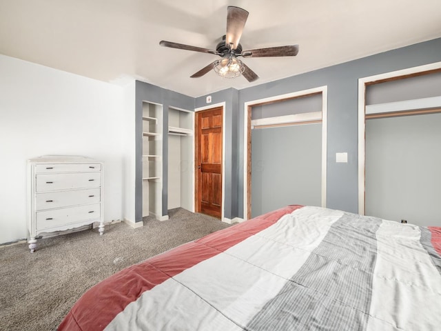 carpeted bedroom with ceiling fan and two closets