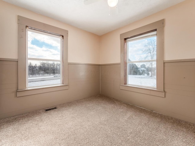 spare room featuring carpet floors and ceiling fan