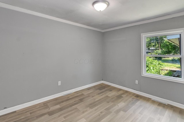 spare room featuring light hardwood / wood-style flooring and ornamental molding