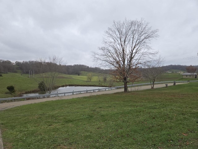 view of yard with a water view and a rural view