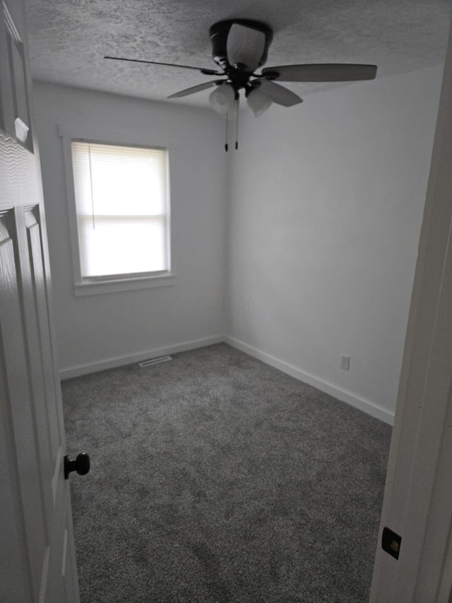 carpeted empty room with baseboards, a textured ceiling, and a ceiling fan