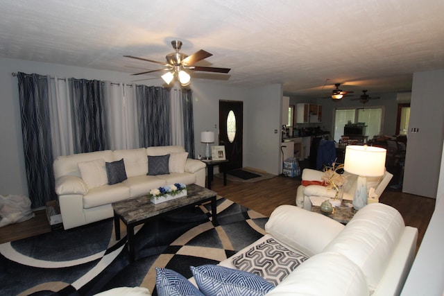 living room with ceiling fan and dark wood-type flooring