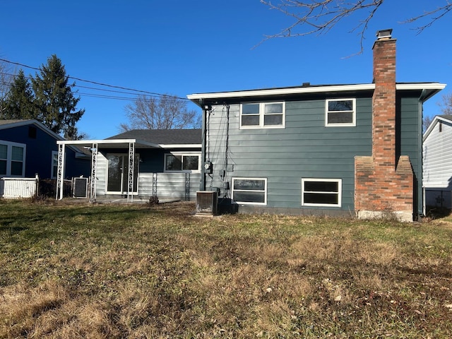 back of house with a yard and central AC