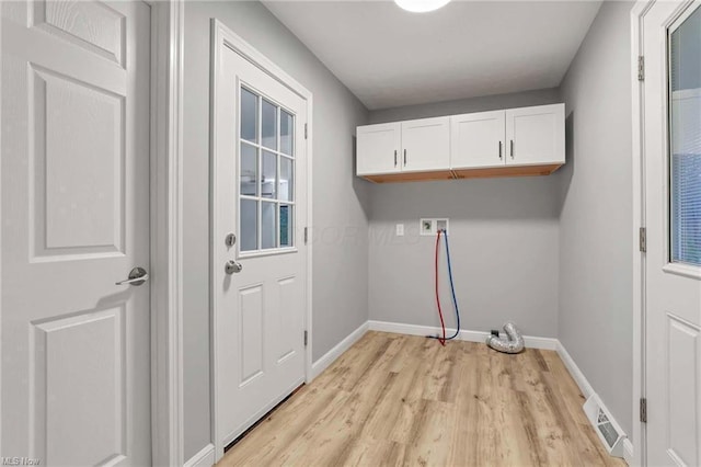 washroom featuring cabinets, hookup for a washing machine, and light hardwood / wood-style flooring