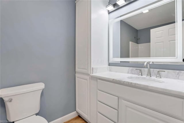 bathroom featuring vanity, toilet, wood-type flooring, and walk in shower