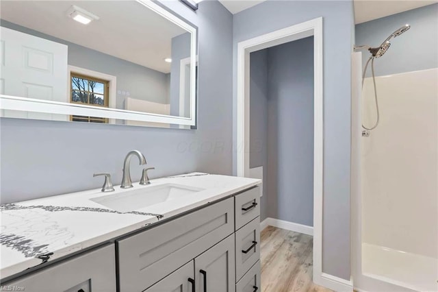 bathroom featuring a shower, vanity, and hardwood / wood-style flooring