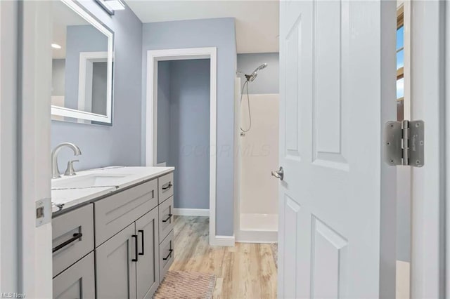 bathroom featuring vanity, wood-type flooring, and walk in shower