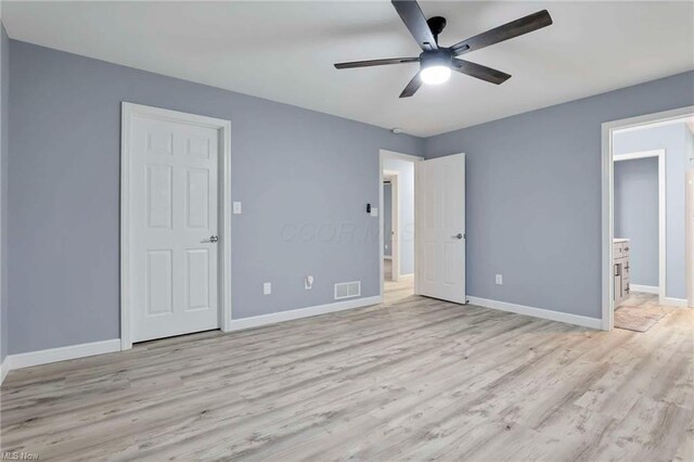 unfurnished bedroom featuring ceiling fan, ensuite bathroom, and light wood-type flooring