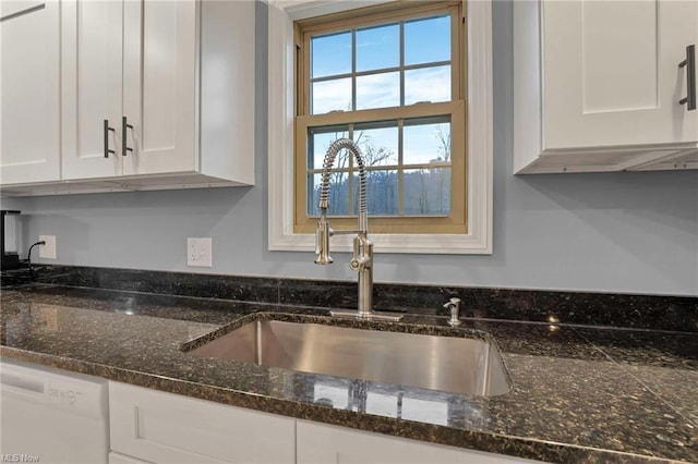 kitchen with white cabinetry, sink, dishwasher, and dark stone counters