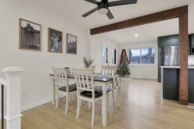 dining space with beamed ceiling, light hardwood / wood-style floors, and ceiling fan