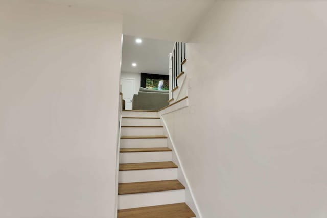 stairs featuring hardwood / wood-style floors