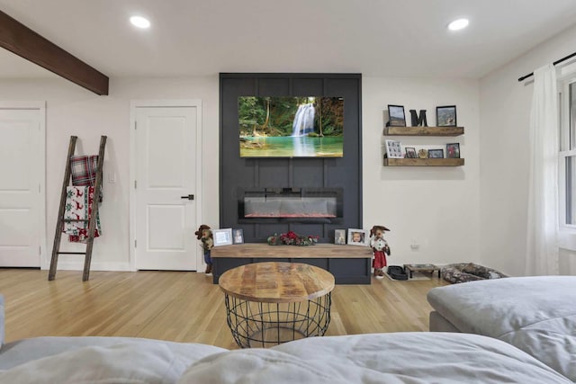 living room featuring a fireplace, hardwood / wood-style floors, and beamed ceiling