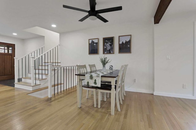 dining area featuring beam ceiling, light wood-type flooring, and ceiling fan