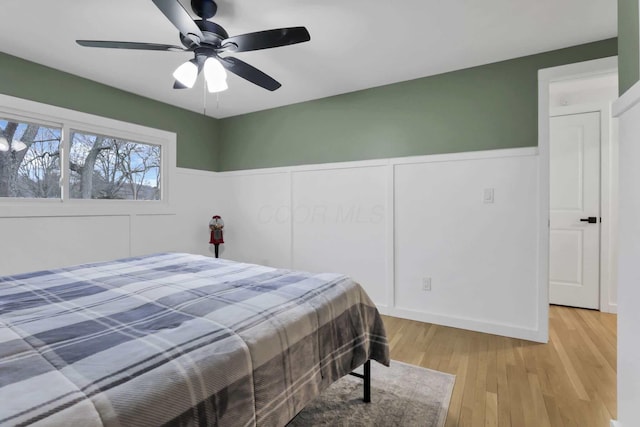 bedroom featuring ceiling fan, light hardwood / wood-style floors, and a closet