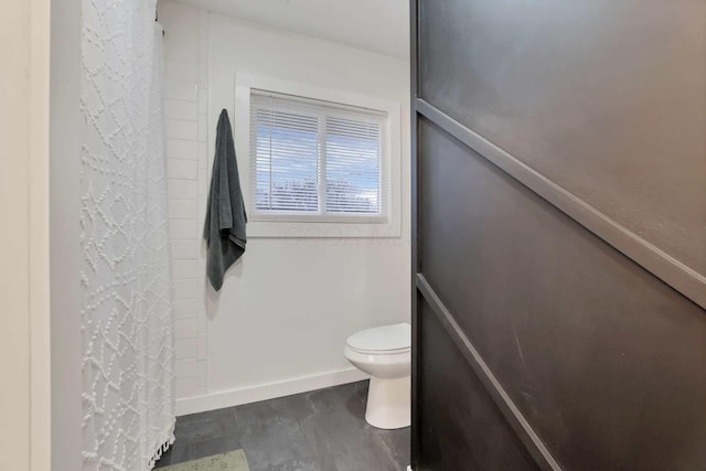 bathroom featuring a shower with curtain and toilet