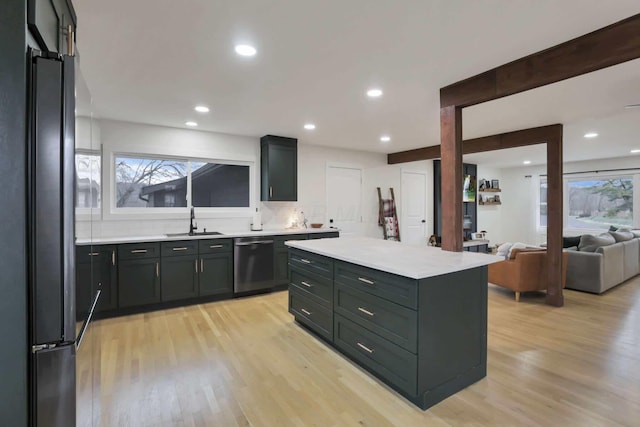 kitchen with appliances with stainless steel finishes, light hardwood / wood-style floors, a kitchen island, and sink