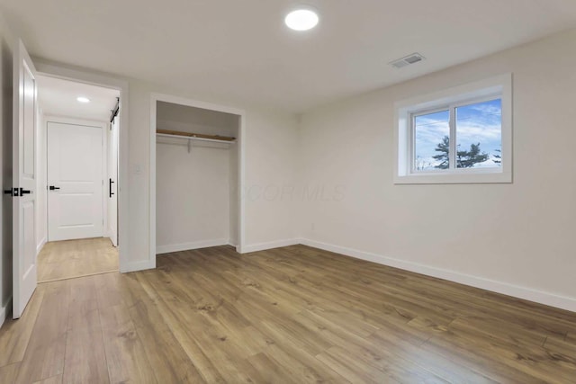 unfurnished bedroom featuring light hardwood / wood-style flooring and a closet