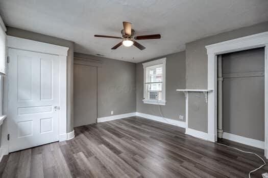 unfurnished bedroom featuring a closet, dark hardwood / wood-style floors, and ceiling fan