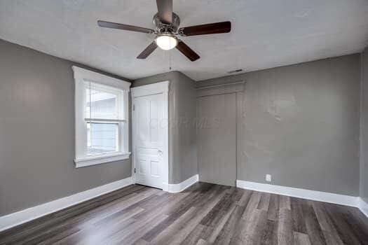 unfurnished bedroom featuring ceiling fan and dark wood-type flooring