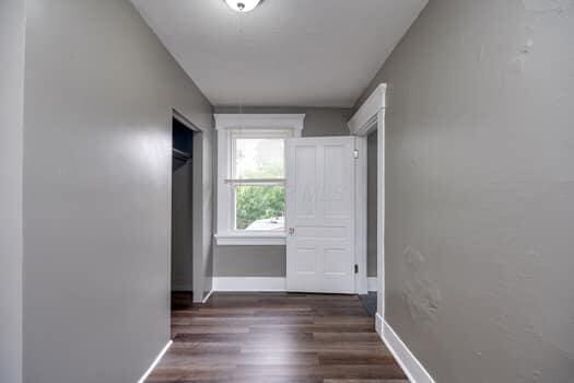 corridor with dark hardwood / wood-style flooring