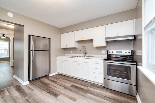 kitchen with stainless steel appliances, ceiling fan, sink, light hardwood / wood-style flooring, and white cabinetry