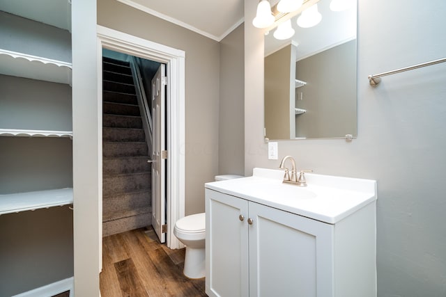 bathroom featuring vanity, hardwood / wood-style flooring, toilet, and crown molding