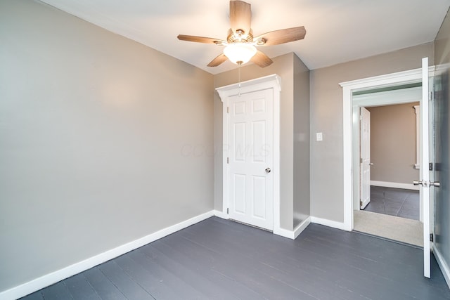 unfurnished bedroom featuring ceiling fan and dark hardwood / wood-style floors