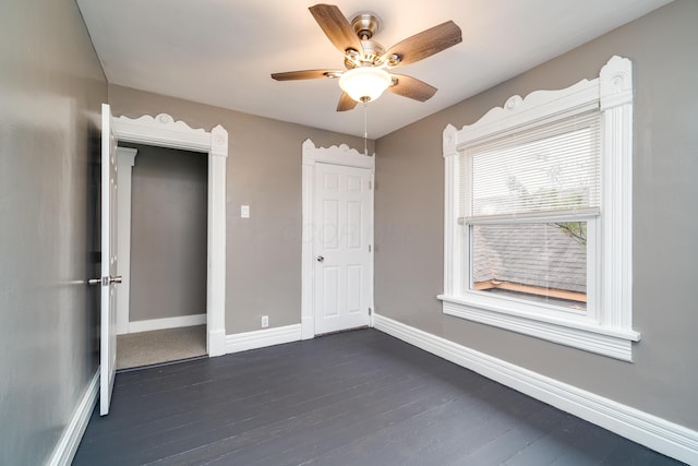 unfurnished bedroom with a closet, ceiling fan, and dark wood-type flooring