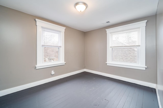 unfurnished room featuring plenty of natural light and dark hardwood / wood-style flooring